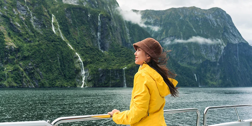 Kvinna seglar i Milford Sound, Nya Zeeland