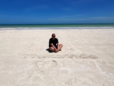 Tom sitter i sanden på Isla Holbox i Mexiko.