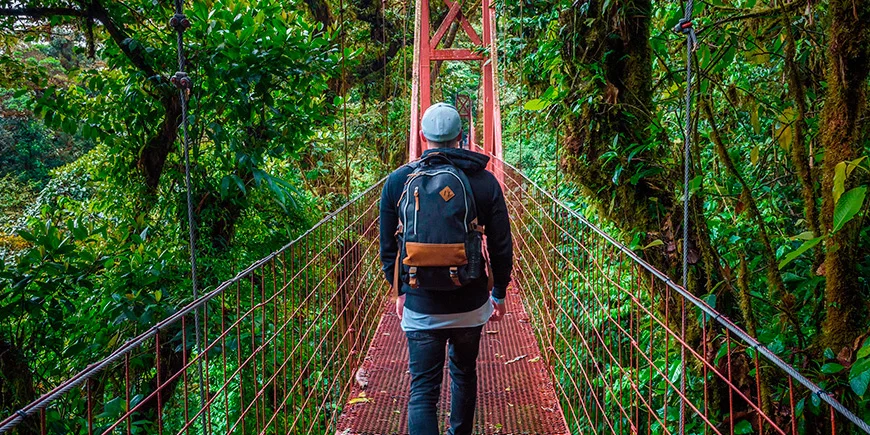 Man som går ensam på en hängbro i Monteverde Cloud Forest i Costa Rica