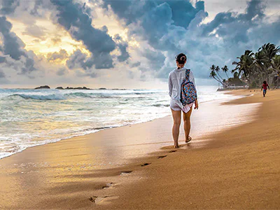 En kvinna går på stranden på Sri Lanka