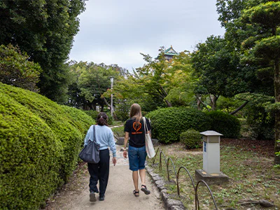 Japansk guide går tillsammans med en TourCompass-medarbetare vid Osaka Castle i Japan