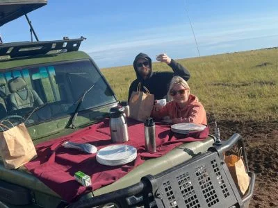 Två personer äter frukost i safaribilen